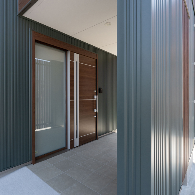 奥行たっぷりで囲われた玄関ポーチ。自転車が雨や雪に濡れない十分なスペースを確保。仙台の冬の積雪時も落ち着いて出入りできる、機能的な注文住宅の外構設計。