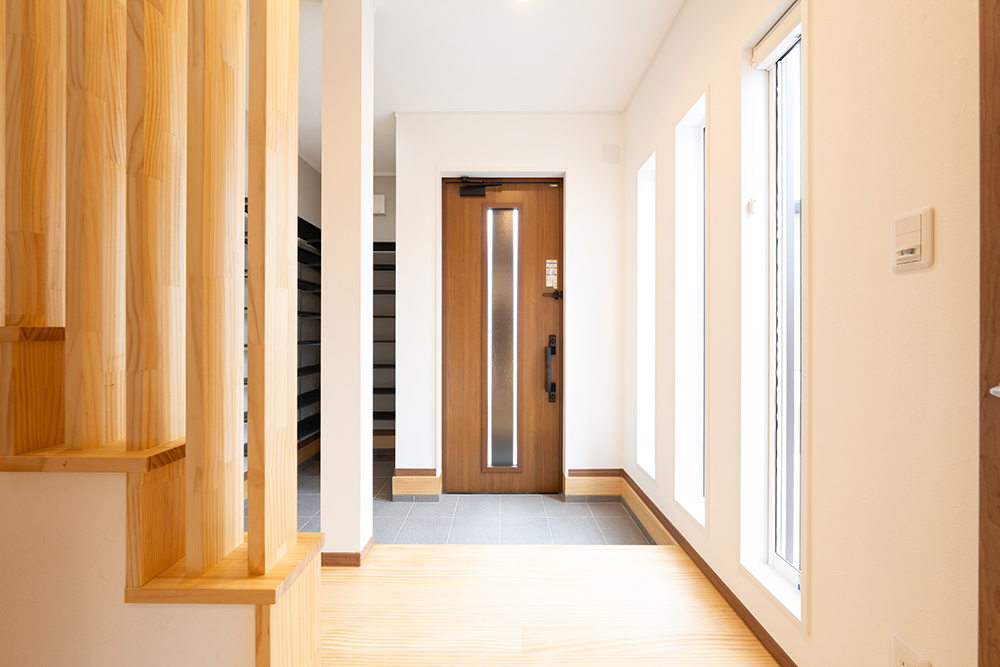 仙台市の狭小住宅における玄関土間とつながるオープンタイプのシューズクローク。濡れた上着や長靴もそのまま置ける、共働き世帯に人気の注文住宅の間取り例。